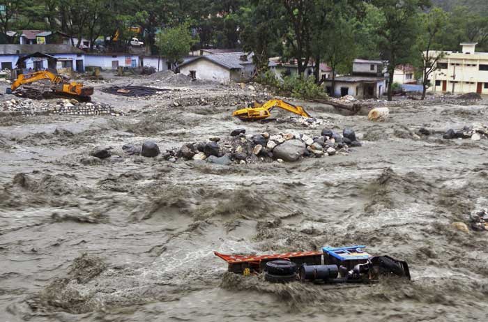 bulldozer-and-other-vehicles-are-drifted-in-a-flooded-river-in-uttarkashi-district